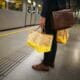 Zwei Tragetaschen/ Einkaufstaschen des BILLA Online Shops getragen von Businessmann in U-Bahn auf Bahnsteig